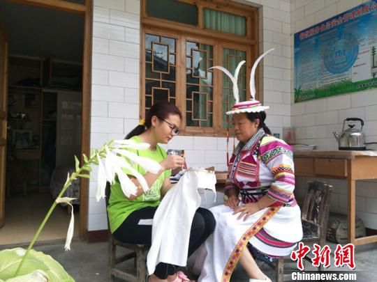 图为志愿者与甘肃陇南文县白马藏族妇女一起制作特色文化产品。　李铭垣 摄