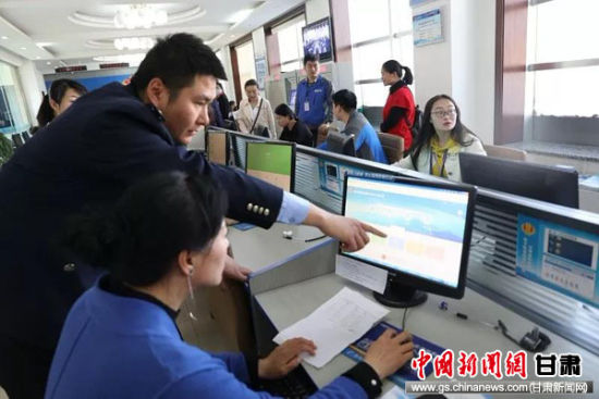 肃州区税务局党团员突击队员在申报期进驻办税服务厅，辅导纳税人自助办税。