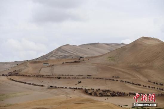 资料图：游客骑骆驼在敦煌鸣沙山月牙泉景区游览。 中新社记者 杨艳敏 摄