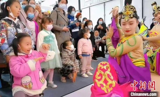 图为敦煌舞者在湖北武汉文旅博览会展区，教当地小朋友敦煌舞舞姿。(资料图) 甘肃省文化和旅游厅供图