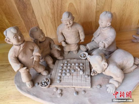 图为泥塑作品展现下棋场景。 刘玉桃 摄