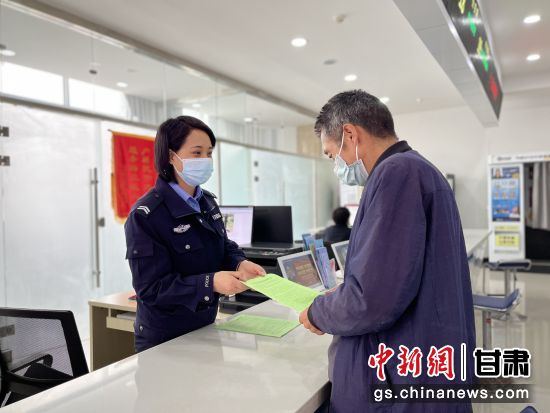 图为灵台县公安局户政窗口民警为办理业务的老年人普及反诈知识.