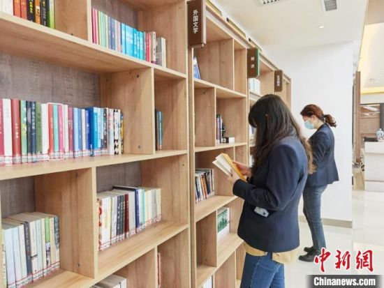 图为在甘肃公航旅建设集团有限公司的职工书屋，职工挑选书籍。　徐雪 摄